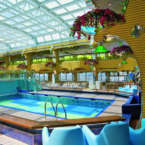 A swimming pool area with yellow decor and blue seating