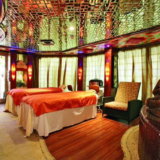 A spa with a reflective ceiling and a buddha statue