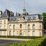 An image of an elegant house in Macon, France, with a low hedge surrounding it