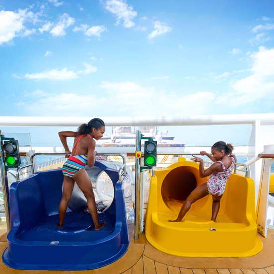 Two kids at the top of parallel water slides