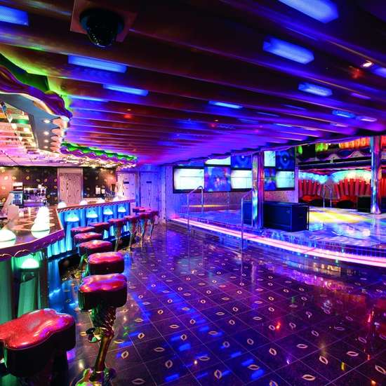 A stylish bar with bright lights and a dance floor