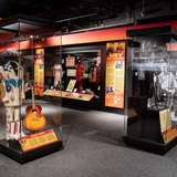 An image of a museum interior with glass display cabinets showcasing country music costumes and instruments