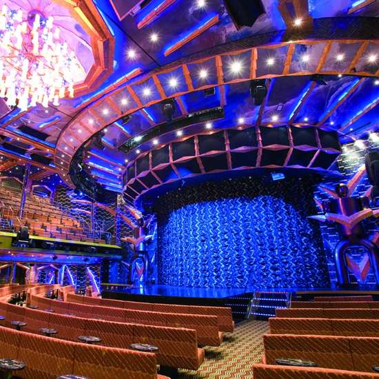 An extravagant theatre stage with colourful decor and blue curtains