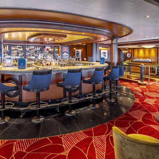 A bar with blue stool-chairs and red carpet