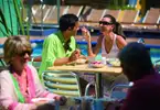 A younger couple enjoying breakfast outside, overlooking a pool area