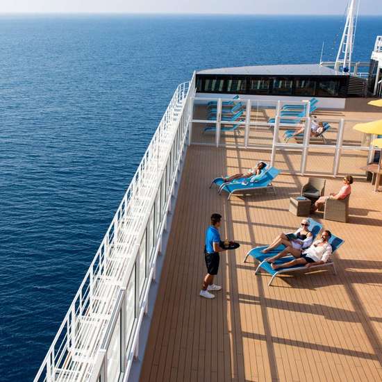 People sun loungers in the solarium space, overlooking an open ocean