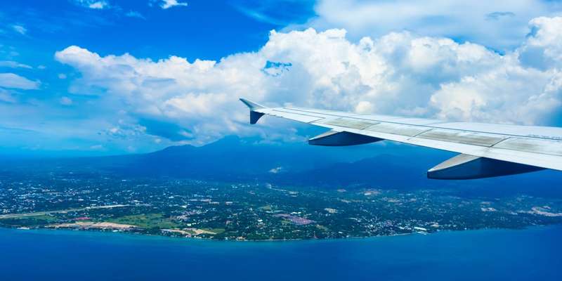 An image of the Philippines from an aeroplane window, with the tip of the wing in frame