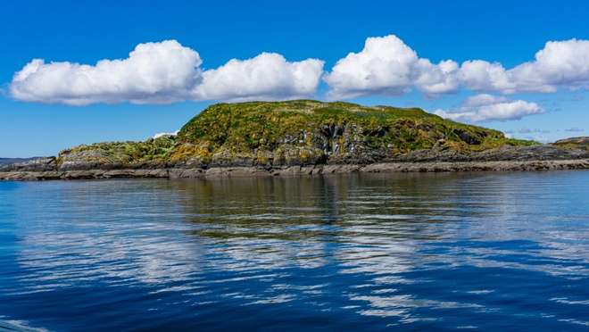 Visit a tiny, eco-pioneering Hebridean island crowned by a distinctive volcanic ridge.