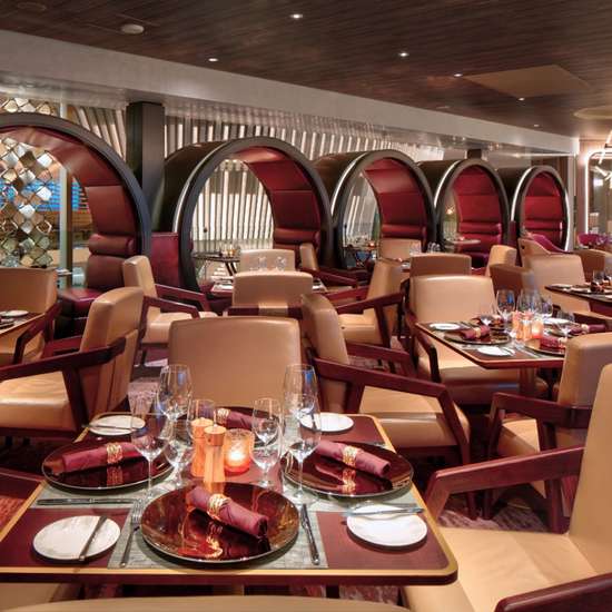 The interior of the Fine Cut Steakhouse on Celebrity Beyond, a smart restaurant with warm-coloured interiors