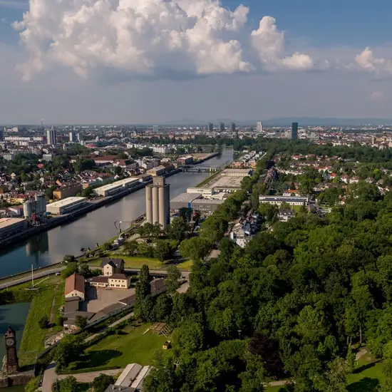 Image related to An image of Ludwigshafen from afar, with the river flowing and green trees in the foreground