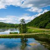 A nature reserve with a lake split by a raised dirt road.