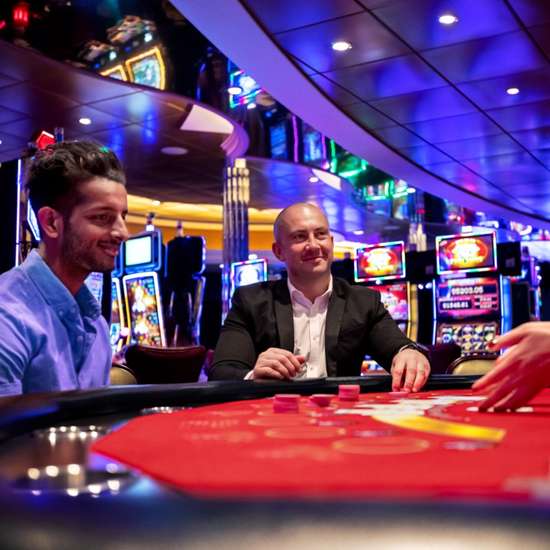 Two people sat at a blackjack table in a casino
