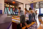 Three kids playing Skee-Ball in High Score