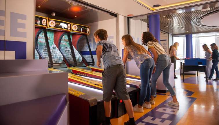 Three kids playing Skee-Ball in High Score