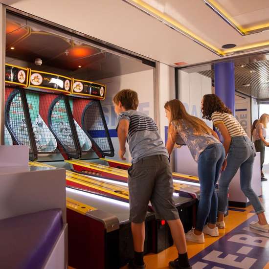 Three kids playing skee-ball