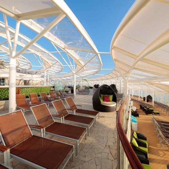 A shaded seating area with deck chairs and sun loungers