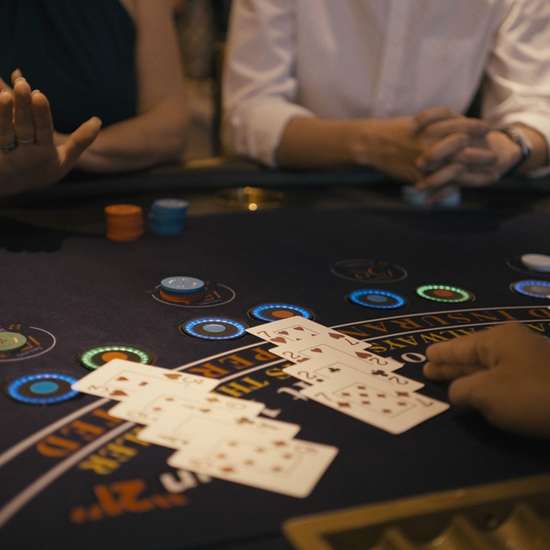 Someone playing blackjack at a casino, focusing on the table