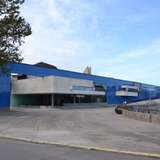 A modern museum building with a bright blue exterior