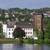 An impressive white-walled castle with a brick tower
