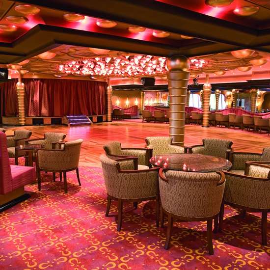 Tables and chairs surrounding a dance floor with a stage