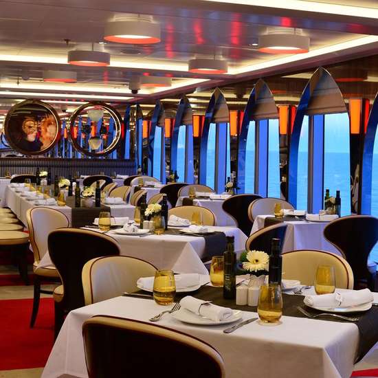 Tables and chairs in a stylish restaurant with white table cloths and red carpeting